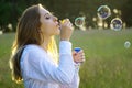 Pretty brunette young woman on a meadow blowing soap bubbles Royalty Free Stock Photo