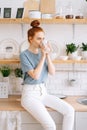 Pretty business lady drinking tasty beverage from mug at home office in during break Royalty Free Stock Photo