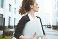 Pretty business woman hold modern laptop and stand among urban space Royalty Free Stock Photo