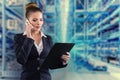 Pretty businesswoman with clipboard talks on phone with warehouse background Royalty Free Stock Photo