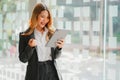 Pretty businesswoman holding a digital tablet while standing in the office with copy space Royalty Free Stock Photo