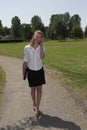 Pretty businesswoman in the park; on the phone