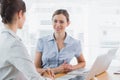 Pretty businesswoman smiling at camera with her colleague Royalty Free Stock Photo