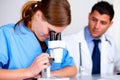 Pretty caucasian doctor girl using a microscope Royalty Free Stock Photo