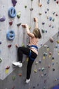 Pretty Caucasian girl climbering artificial rock-climbing walls Royalty Free Stock Photo