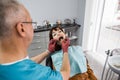 Pretty Caucasian girl having mouth checkup in modern dental clinic. Young female patient receiving dental care