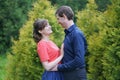 Pretty caucasian love couple walking in the green summer park, having smiles, kisses and hugs Royalty Free Stock Photo