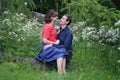 Pretty caucasian love couple walking in the green summer park, having smiles, kisses and hugs Royalty Free Stock Photo