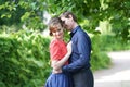 Pretty caucasian love couple walking in the green summer park, having smiles, kisses and hugs Royalty Free Stock Photo