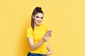 Pretty caucasian woman listening to music from her phone and headphones over yellow background Royalty Free Stock Photo