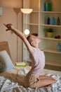 Slim caucasian woman yogi sits on bed stretching after yoga exercise