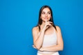 Pretty charming young woman having secret while holding finger on lips and showing silence sign while standing on blue background Royalty Free Stock Photo