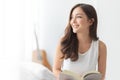 Pretty Charming Young Woman sitting smiling looking out at bedroom in the morning. Relaxed Beautiful female enjoying at home. Royalty Free Stock Photo