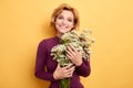 Pretty cheerful positive blonde girl enjoying her flowers