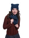 Pretty cheerful young woman wearing knitted sweater, scarf and hat. Isolated on white background. She is smiling.