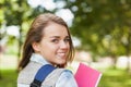 Pretty cheerful student smiling at camera carrying notebook Royalty Free Stock Photo