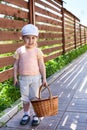 Pretty child with basket walking on house courtyard