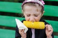 Pretty child girl eats a boiled corn