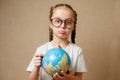 Little girl with glasses is pointing to a place on a globe Royalty Free Stock Photo