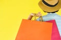 Pretty child girl hands holding shopping bag isolated on yellow background - Asian young woman happy summer shopping and enjoys Royalty Free Stock Photo