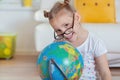 Pretty child girl at home dreaming of travel and tourism, exploring the world and globe Royalty Free Stock Photo