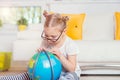 Pretty child girl at home dreaming of travel and tourism, exploring the world and globe Royalty Free Stock Photo