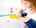 Pretty child girl smears yellow paint on hands Royalty Free Stock Photo