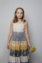 Pretty child girl wearing summer dress standing against gray studio wall background, fashion portrait Royalty Free Stock Photo