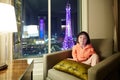 Little girl in hotel room with Eiffel Tower night scene outside