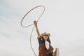 Pretty Chinese cowgirl throwing the lasso in a horse paddock