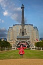 Pretty Chinese girl jumping in front of Eiffel Tower, Macao