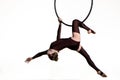 Pretty circus aerialist in brown leotard is spinning upside down on an aerial ring. A young woman performs acrobatic Royalty Free Stock Photo