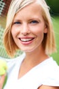 Pretty competitive. Portrait of a young female tennis player holding a ball and racquet. Royalty Free Stock Photo