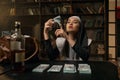 Pretty confident woman in nun dress sitting at table with money stacks