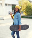 Pretty cool smiling young african woman with skateboard Royalty Free Stock Photo