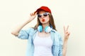 Pretty cool woman in sunglasses and red cap over white