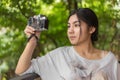 Asian woman holding mirrorless camera in the coffee cafe Royalty Free Stock Photo