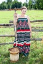 Pretty country woman with wooden rake and bucket