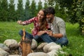 Pretty couple camping with marshmallows over a campfire. Happy young couple relaxing in the backyard Royalty Free Stock Photo