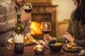 Pretty couple drinking red wine and eating in restaurant, winter time, romantic dinner Royalty Free Stock Photo