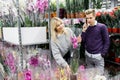 Pretty couple picks orchids in the store. Choice of flowers in a flower shop Royalty Free Stock Photo