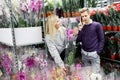 Pretty couple picks orchids in the store. Choice of flowers in a flower shop Royalty Free Stock Photo