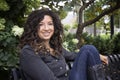 Pretty Curly Haired Woman Smiles into Camera