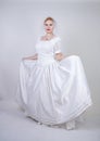 Pretty curvy adult woman with short hair wearing long vintage wedding dress with sun style skirt. young caucasian bride with veil