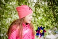 Pretty cute little girl with long hair posing near a blooming apple tree with white flowers in a summer park Royalty Free Stock Photo