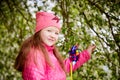 Pretty cute little girl with long hair posing near a blooming apple tree with white flowers in a summer park Royalty Free Stock Photo