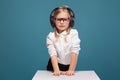 Pretty, cute little girl in white shirt, glasses, black trousers and headphones Royalty Free Stock Photo