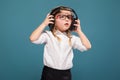 Pretty, cute little girl in white shirt, glasses, black trousers and headphones Royalty Free Stock Photo