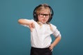 Pretty, cute little girl in white shirt, glasses, black trousers and headphones Royalty Free Stock Photo