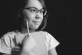 Pretty cute smiling girl in glasses white t-shirt with copybook pencil on black background. black and white image Royalty Free Stock Photo